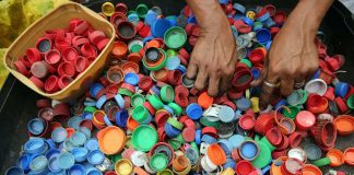 person hands on assorted color plastic lid lot