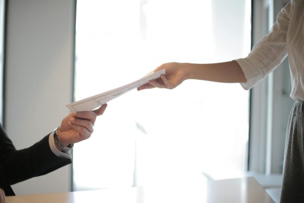 job applicant passing her documents